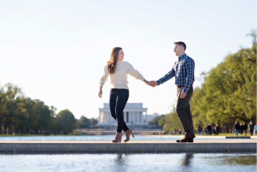 A woman walks with her fiance along the lincoln memorial reflecting pool in DC.